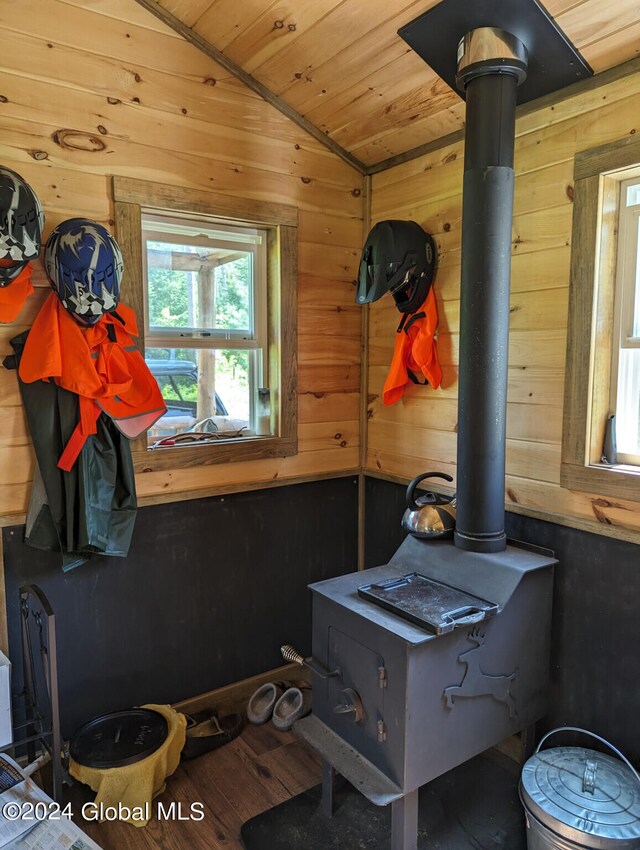 bathroom featuring hardwood / wood-style floors, a wood stove, wood walls, lofted ceiling, and wooden ceiling