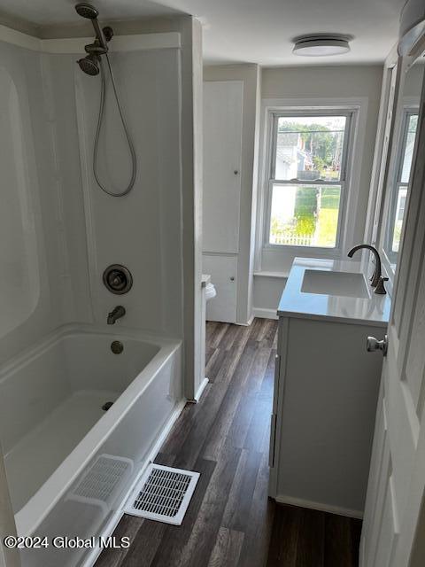 bathroom featuring shower / bathing tub combination, hardwood / wood-style floors, and vanity