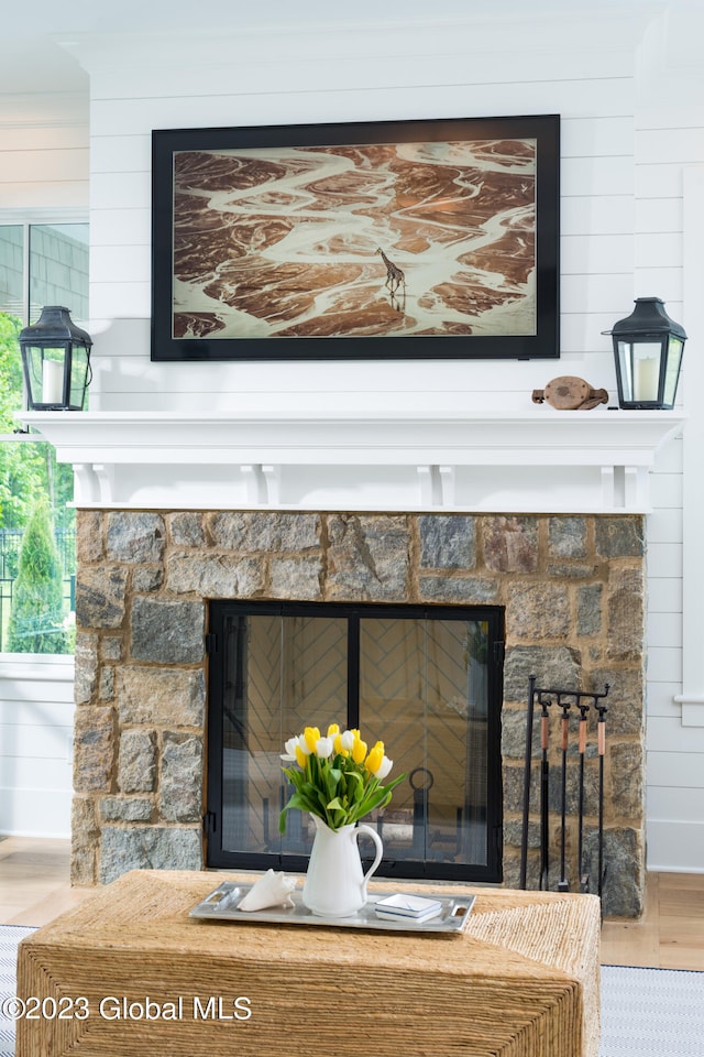 interior details with wooden walls, a fireplace, and hardwood / wood-style floors