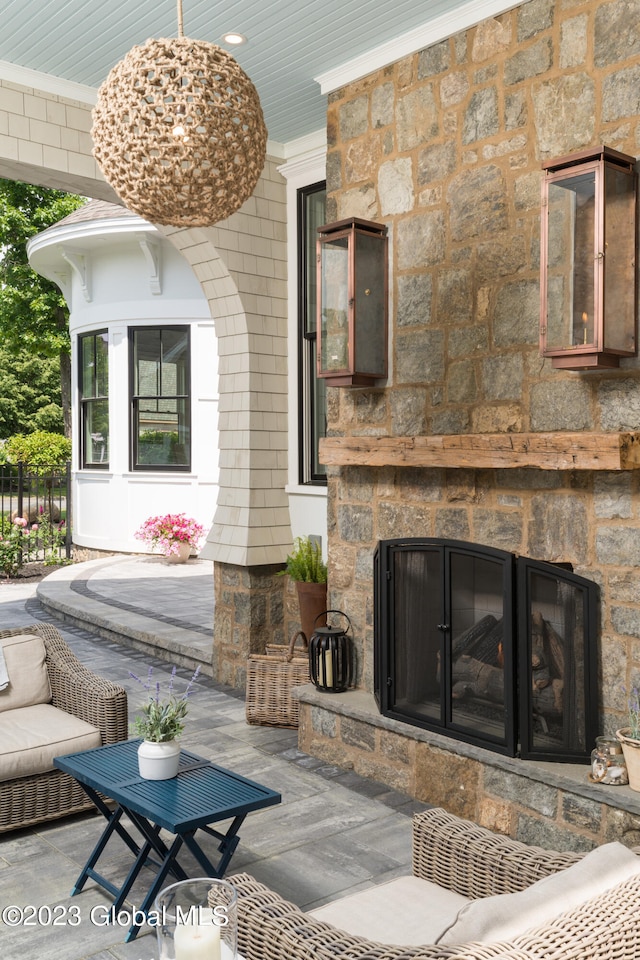 living room featuring ornamental molding, an outdoor stone fireplace, and hardwood / wood-style flooring