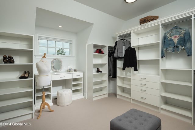 walk in closet featuring light colored carpet