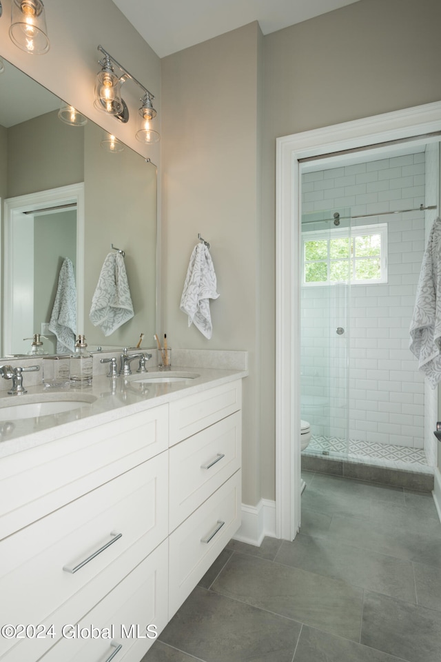 bathroom featuring vanity, toilet, tile patterned flooring, and an enclosed shower