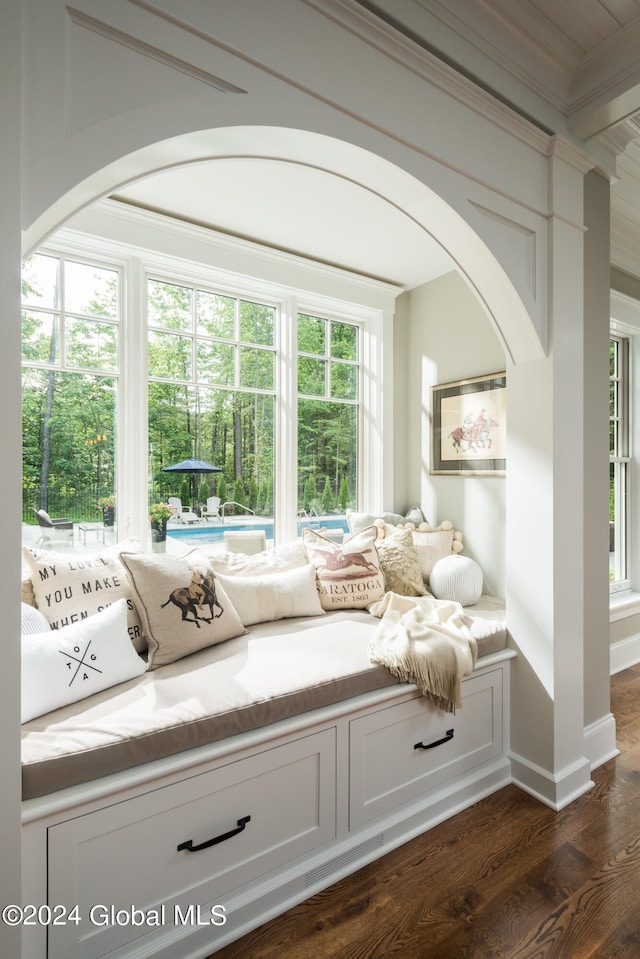 sitting room featuring dark wood-type flooring, crown molding, and plenty of natural light