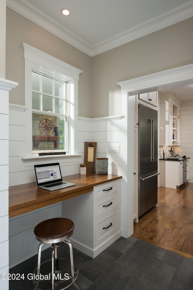 kitchen featuring ornamental molding, butcher block counters, stainless steel built in refrigerator, and white cabinets