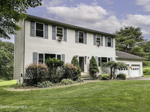 colonial-style house featuring cooling unit, a garage, and a front yard