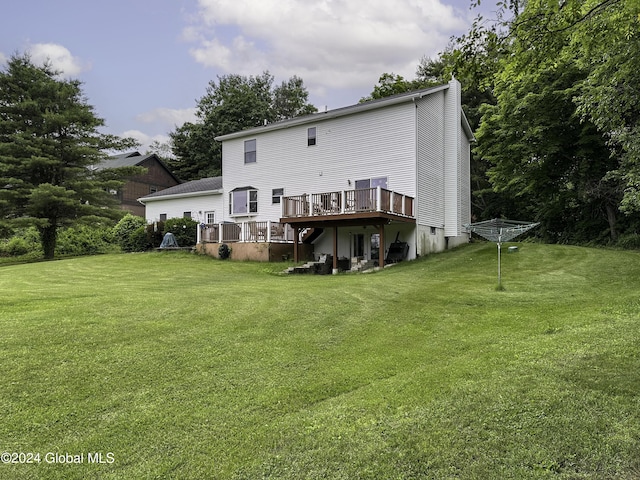 rear view of property with a yard and a wooden deck