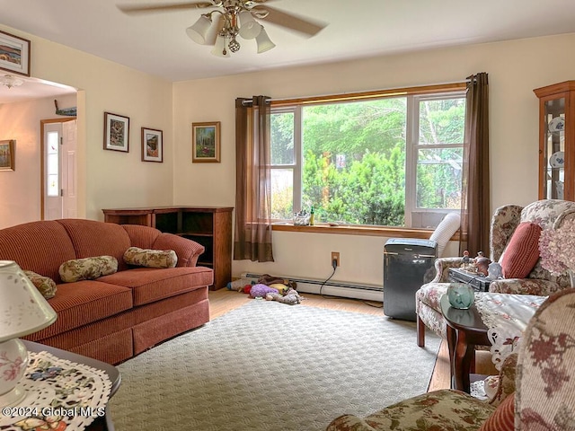 living room featuring ceiling fan, light hardwood / wood-style floors, and a baseboard heating unit