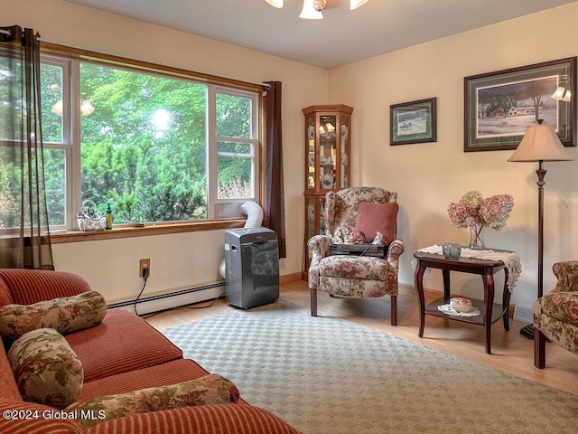 living area with a baseboard radiator and light hardwood / wood-style flooring