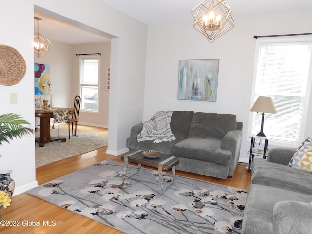 living room featuring wood-type flooring and a notable chandelier