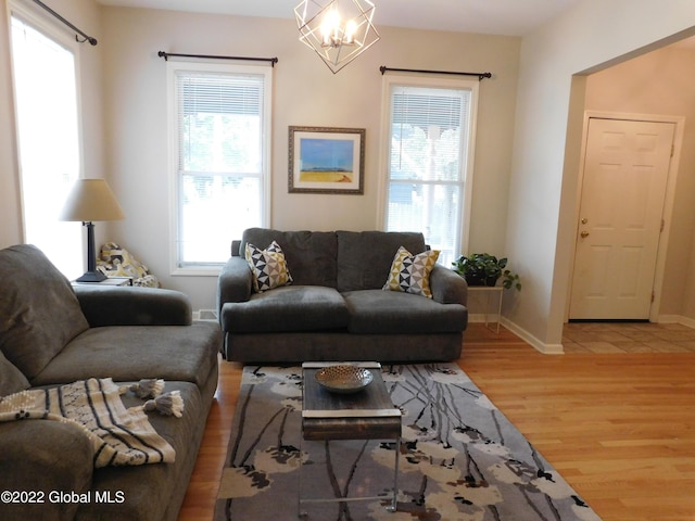 living room featuring wood-type flooring and an inviting chandelier