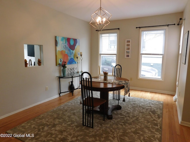 dining space featuring light hardwood / wood-style floors and a notable chandelier