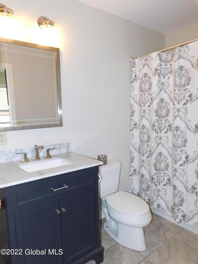 bathroom featuring tile patterned flooring, vanity, and toilet