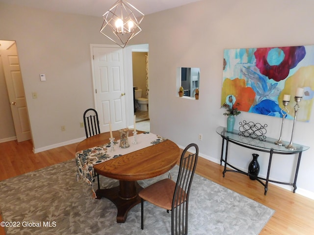 dining space featuring hardwood / wood-style floors and an inviting chandelier