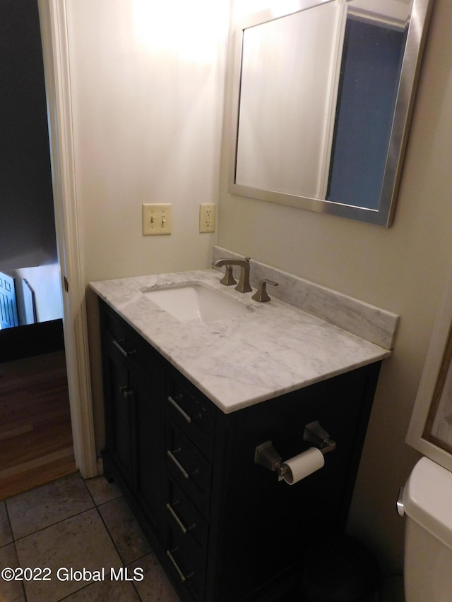 bathroom featuring tile patterned flooring, vanity, and toilet