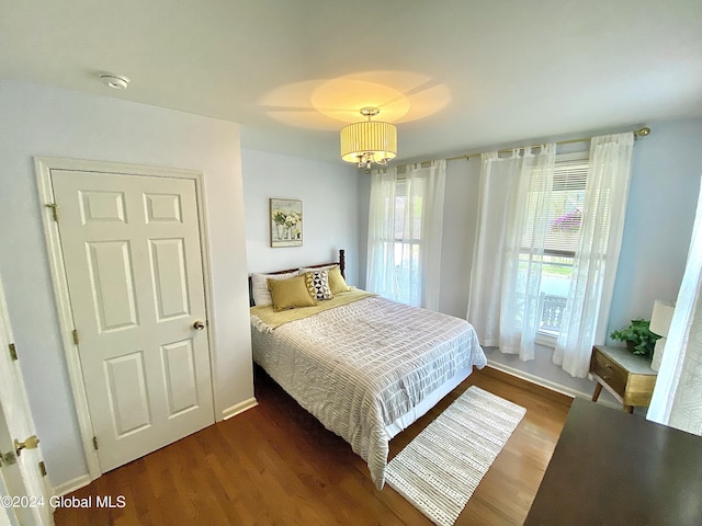 bedroom featuring dark hardwood / wood-style flooring and a chandelier