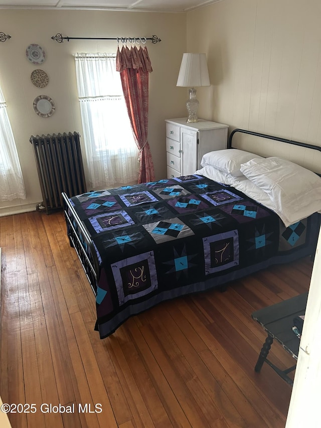 bedroom featuring radiator and hardwood / wood-style flooring