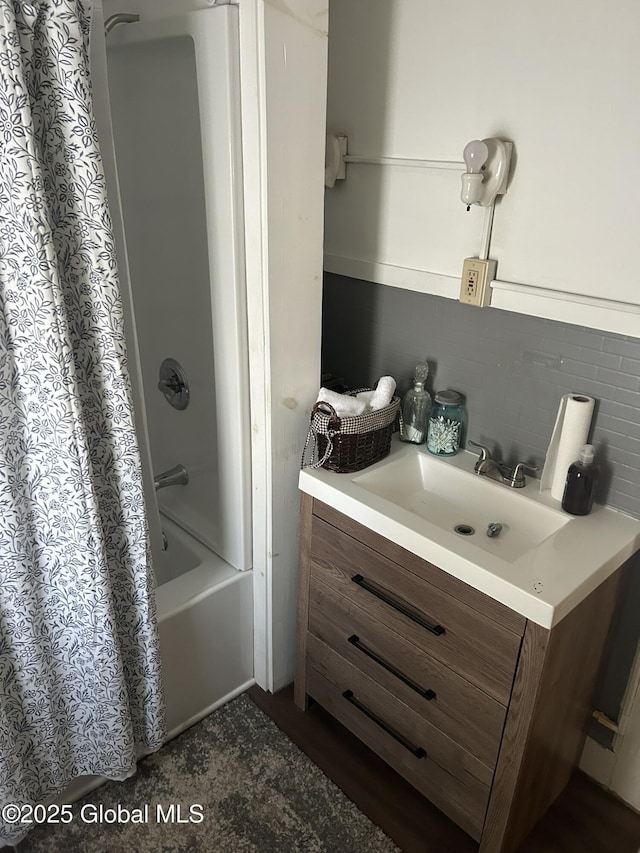 bathroom featuring shower / bathtub combination with curtain, vanity, and backsplash