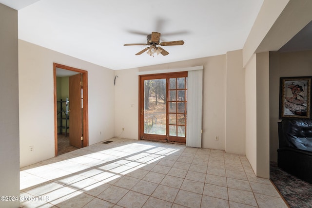 tiled empty room featuring ceiling fan