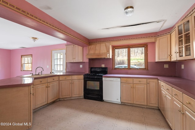 kitchen with dishwasher, sink, black gas range oven, premium range hood, and kitchen peninsula