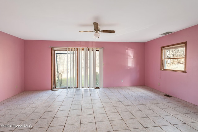 tiled spare room featuring ceiling fan