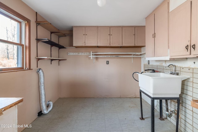 washroom featuring hookup for an electric dryer, cabinets, and sink