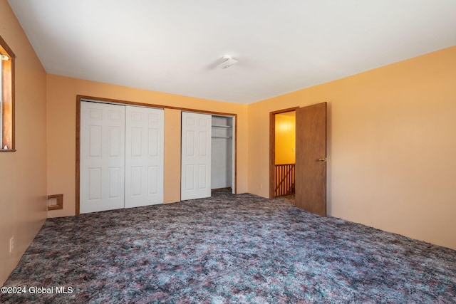 unfurnished bedroom with carpet flooring and two closets