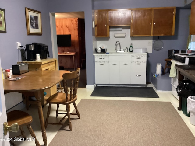 kitchen with white cabinetry, sink, and electric range