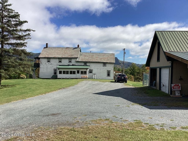 back of property featuring a garage and a yard