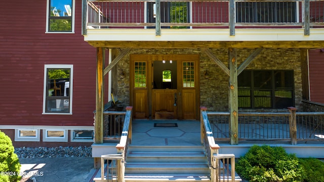 view of exterior entry featuring a balcony