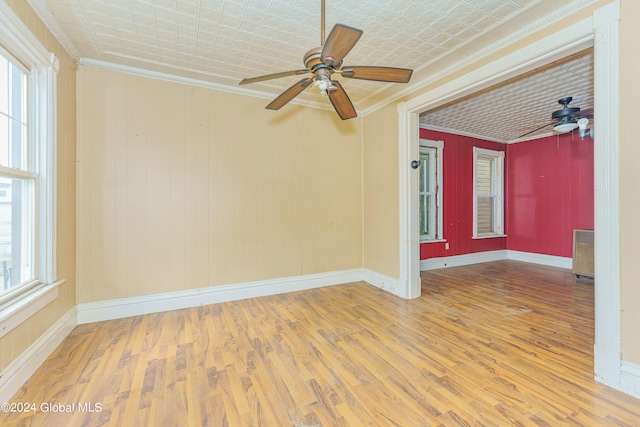 spare room featuring crown molding, hardwood / wood-style floors, and plenty of natural light