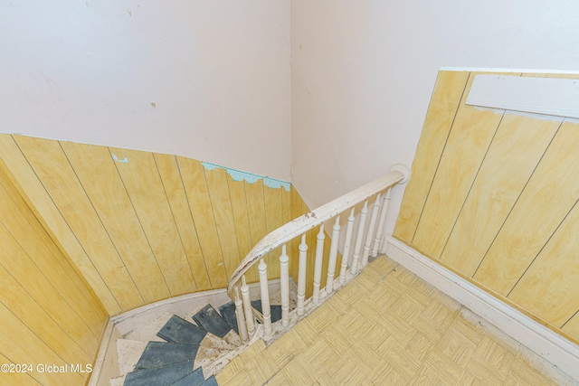 stairway featuring parquet flooring