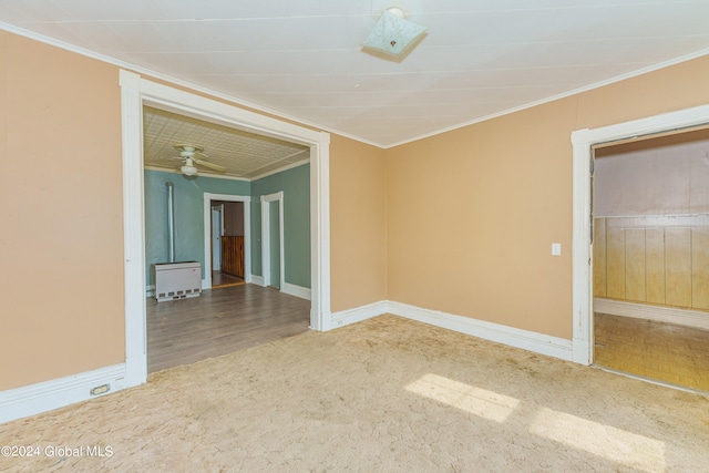 empty room with wood-type flooring, crown molding, and ceiling fan