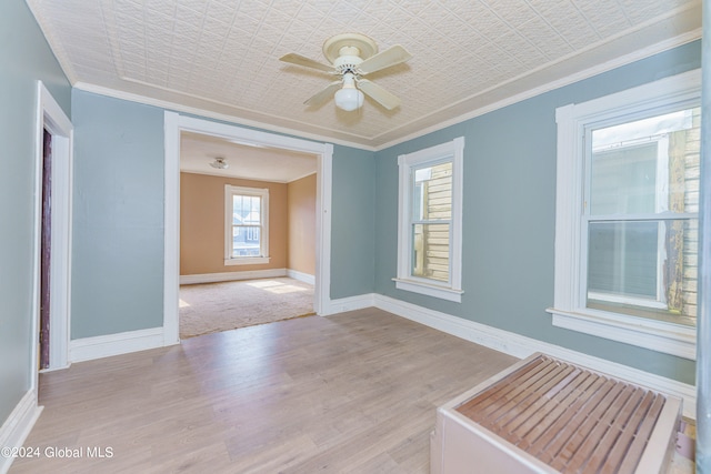 empty room with light hardwood / wood-style floors, ornamental molding, and ceiling fan