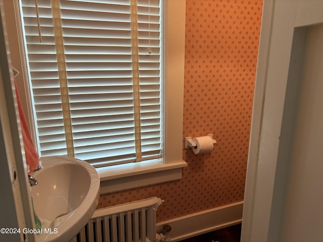 bathroom with radiator heating unit and sink