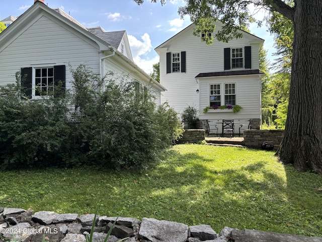 rear view of property with a lawn