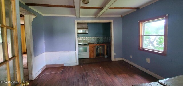 unfurnished living room featuring beam ceiling and hardwood / wood-style flooring