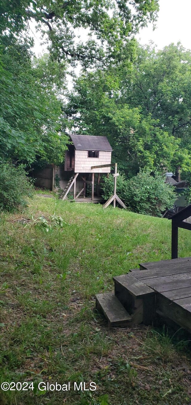 view of yard featuring a deck and an outdoor structure