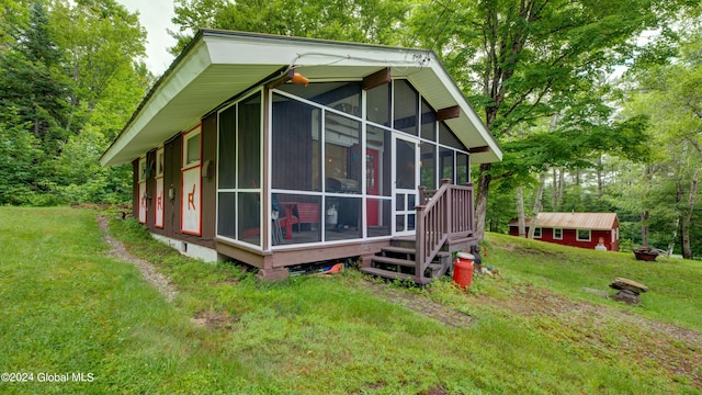 view of side of property with a sunroom and a yard
