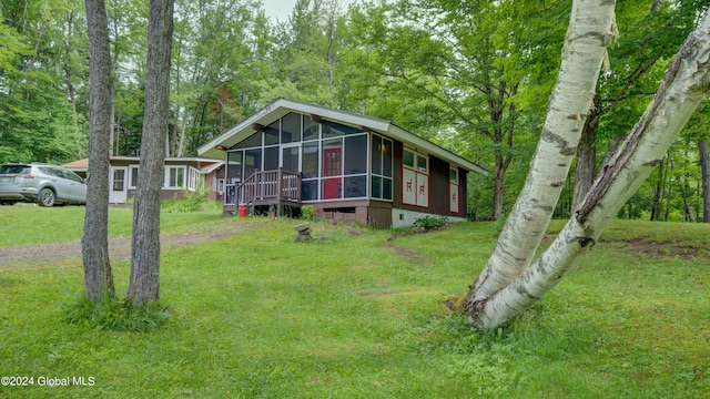 view of front of home with a sunroom and a front yard