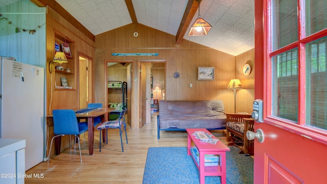 living area with wood finished floors, lofted ceiling, and wood walls