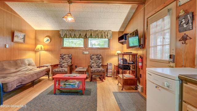 sitting room with light wood-type flooring and wooden walls