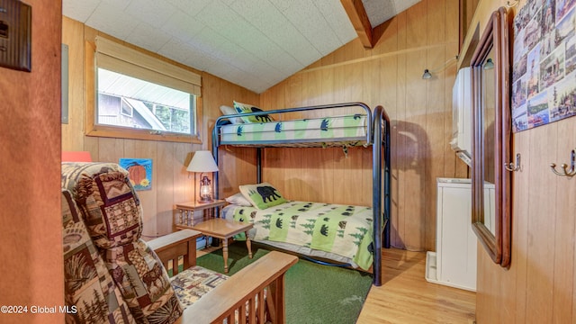 bedroom featuring wood finished floors and wooden walls