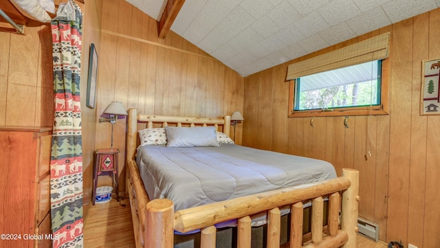 bedroom featuring wooden walls, light wood-style flooring, and a baseboard radiator