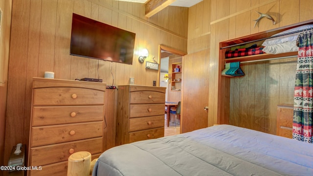 bedroom featuring wood walls and a closet