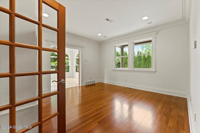 unfurnished room with crown molding and hardwood / wood-style flooring