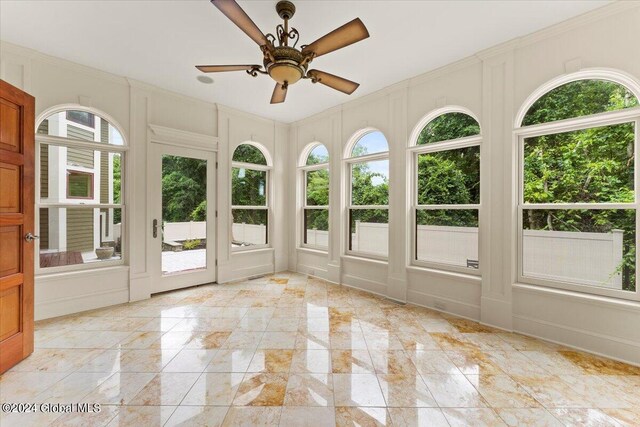 unfurnished sunroom featuring ceiling fan