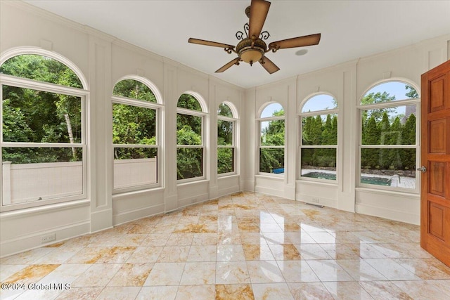 unfurnished sunroom featuring ceiling fan