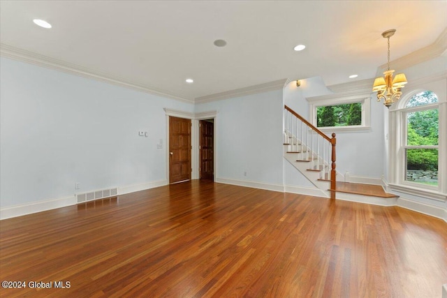 unfurnished room with ornamental molding, an inviting chandelier, and hardwood / wood-style flooring