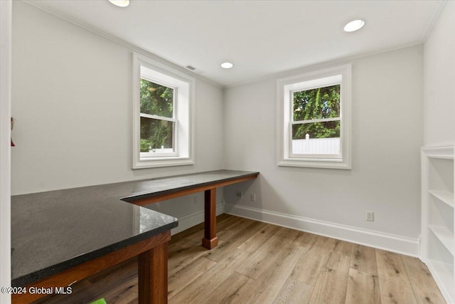 home office with light hardwood / wood-style floors and crown molding