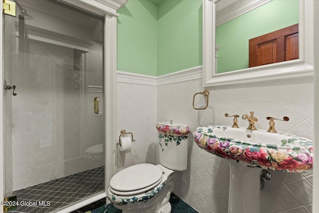 bathroom featuring ornamental molding, a shower with door, and toilet